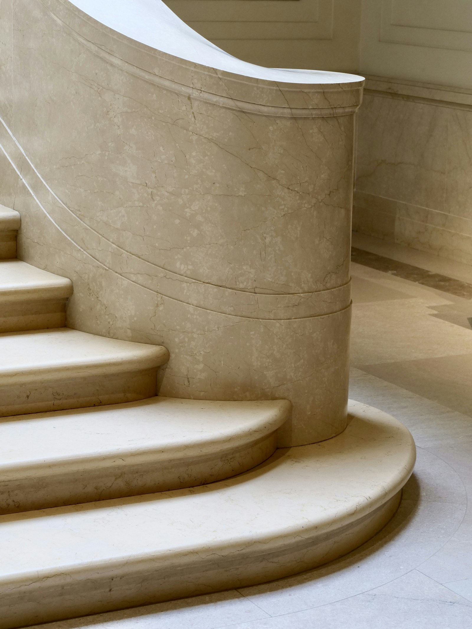 A curved cream marble staircase in soft daylight — Scent Works. Spraying a Nice Smell Around Doesn